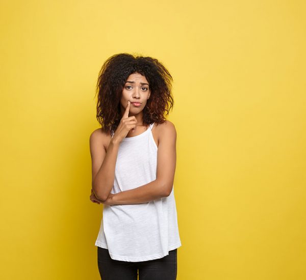 Foto de mulher pensativa, com dúvida se deve comprar ou alugar um imóvel