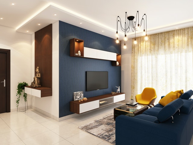 Sala colorida com painel azul e banquetas amarelas